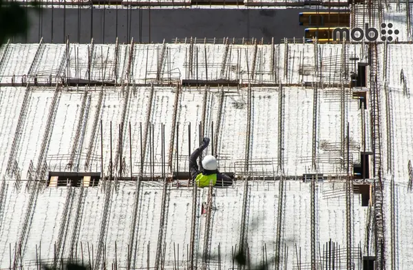Site engineer checking cement bags and TMT bars before ordering cement and steel online