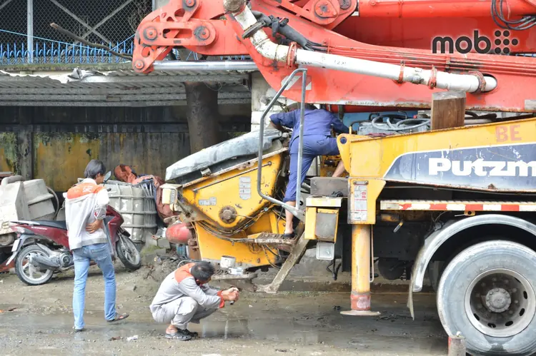 A construction worker inspecting the label on a 50kg cement bag at a building site in Bengaluru.