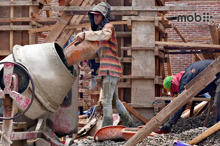 Cement bags stored on a raised platform at an Indian house construction site